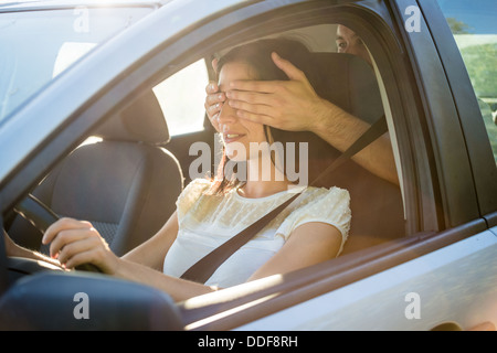 Coppia giovane in auto - l'uomo che copre gli occhi della sua fidanzata Foto Stock
