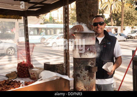 Malaga, Spagna, 22 novembre. 2012. Un allegro i venditori di strada che vende le caldarroste. Un gustoso snack tradizionali in inverno Foto Stock