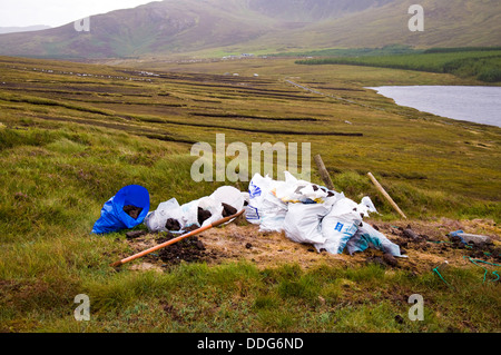 Turf scavi sulla coperta bog con sacchetti di plastica di manto erboso in attesa di raccolta vicino Glencomcille County Donegal Irlanda Foto Stock