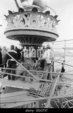 Lavoratori abbassare il recentemente ristrutturato a fiamma e balaustra complessivo sulla base della torcia della Statua della Libertà Novembre 25, 1985 a Liberty Island, New York. Il restauro è stato intrapreso per il centenario. Foto Stock