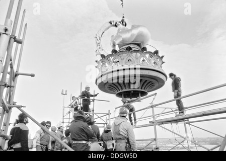 Lavoratori abbassare il recentemente ristrutturato a fiamma e balaustra complessivo sulla base della torcia della Statua della Libertà Novembre 25, 1985 a Liberty Island, New York. Il restauro è stato intrapreso per il centenario. Foto Stock