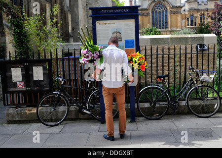 Una vista posteriore di un uomo con fiori in entrambe le mani. Oxford, Regno Unito. Foto Stock