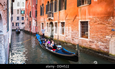 Gondole con i turisti in barca a vela su un water street a Venezia Italia Foto Stock