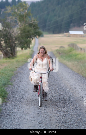 Sposa e lo sposo in sella ad una bicicletta in tandem sul loro giorno di nozze in Oregon Wallowa della valle. Foto Stock