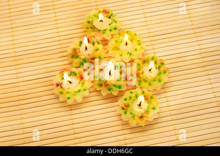 Candela fiori su sfondo di bambù. Foto Stock