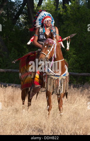 In guerriero Comanche abbigliamento equitazione cavallo di castagno Foto Stock