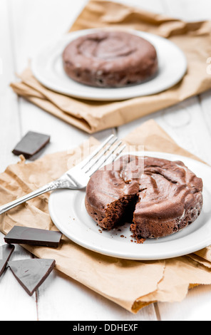 Due fondenti al cioccolato bianco su tavola in legno rustico Foto Stock