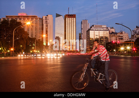 Giovane uomo seduto sulla sua moto in attesa al crocevia di Av del Libertador - Crucero Gral Belgrano Foto Stock