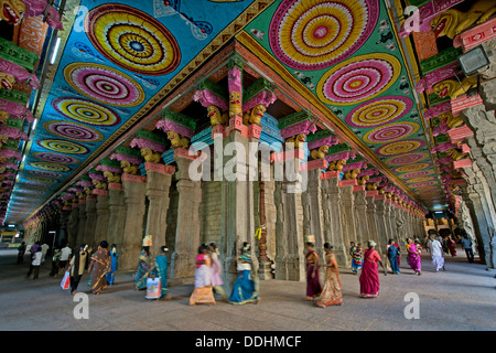 Colorato il soffitto dipinto su colonne in pietra, temple hall con i visitatori, Meenakshi Amman Tempio o Sri Meenakshi Sundareswarar Foto Stock