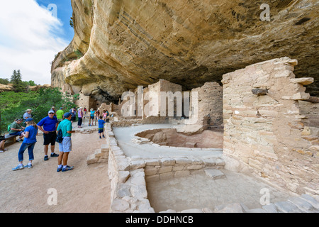 Turisti presso le rovine di Spruce Tree House, antiche abitazioni di Anasazi pueblo, Mesa Verde National Park, Cortez, USA. Dimora scogliera. Foto Stock