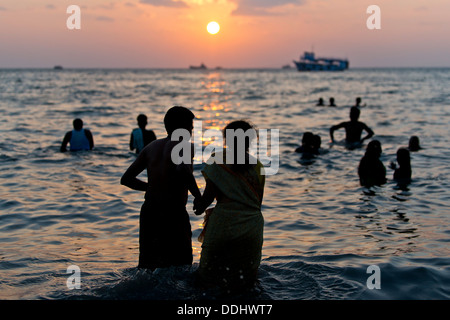 Pellegrini indù di prendere un bagno di Santo in mare presso sunrise, a Ghat Agni Theertham Foto Stock