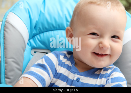 Bambino seduto nel seggiolone Foto Stock