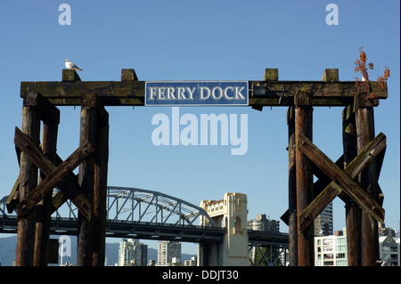 Traghetto in legno segno dock con Burrard ponte in background, Granville Island, Vancouver, British Columbia, Canada Foto Stock