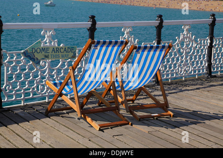 Sedie a sdraio sul molo di Brighton East Sussex England Regno Unito Foto Stock