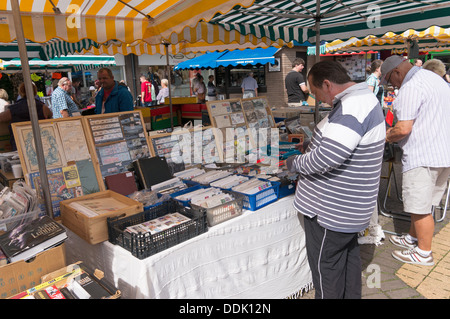 L'uomo navigando attraverso il francobollo collezione sul mercato in stallo Newton Abbot, England, Regno Unito Foto Stock