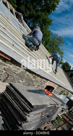 Llanwrda, Wales UK 4° settembre 2013. Costruttori Brian bianco e Jim Hill mettendo un nuovo tetto su un territorio rurale gallese fienile in pietra nel favoloso sole meteo. Kathy deWitt/Alamy Live News Foto Stock