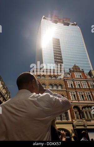 Londra, Regno Unito. Il 4 settembre 2013. I londinesi esperienza l'inaspettato intensità dei raggi solari, riflessa fuori piastra concava finestre di vetro di una delle capitali più recente di grattacieli. L'hotspot ha sorpreso gli sviluppatori e i passanti da sotto e che ha già allo stato fuso di un'auto parcheggiata in Eastcheap Street nella città di Londra. Termometri collocati in strada ha raggiunto 144F (62 celsius) e la città di lavoratori in versato fuori dei loro uffici a pranzo per sperimentare la luce intensa e calore. Copyright Richard Baker / Alamy Live News Foto Stock