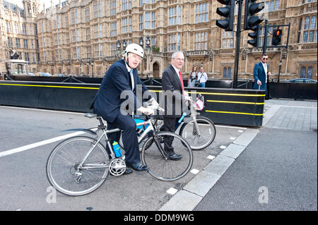 London, Regno Unito - 4 Settembre 2013: il sindaco di Londra Boris Johnson e il London's Transport commissario, Sir Peter Hendy, cavalcare le loro biciclette in Westminster dopo l inaugurazione di un certo numero di misure per affrontare il problema di un veicolo pesante (HGV) sicurezza come parte di uno sforzo comune per potenziare la bicicletta nella capitale. Credito: Piero Cruciatti/Alamy Live News Foto Stock