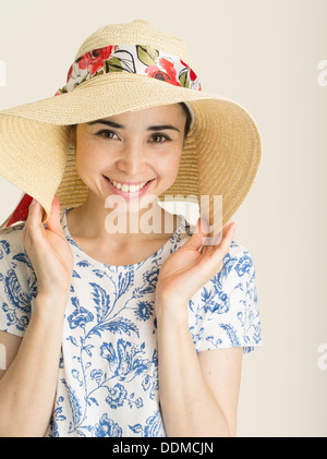 Giovane donna con pelle pallida di stare fuori il sole con ampia colmato cappello per il sole. Prevenzione di ustione solare / melanoma della pelle Foto Stock