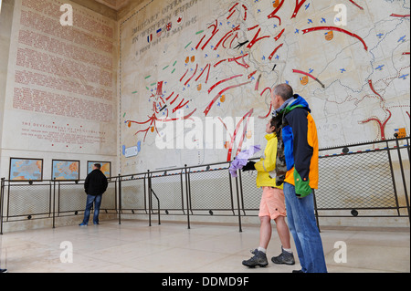 Visitatori presso la spiaggia di Omaha American cimitero di guerra osservando la mappa di grandi dimensioni che mostra la progressione dello sbarco in Normandia. Foto Stock