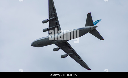 Antonov 124-100-82073 UR jumbo jet transporter cargo aereo underbelly luci di atterraggio su lembi verso il basso cielo molto nuvoloso Foto Stock