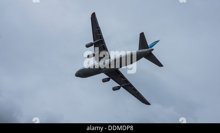 Antonov 124-100-82073 UR jumbo jet transporter cargo aereo underbelly luci di atterraggio su lembi verso il basso cielo molto nuvoloso Foto Stock