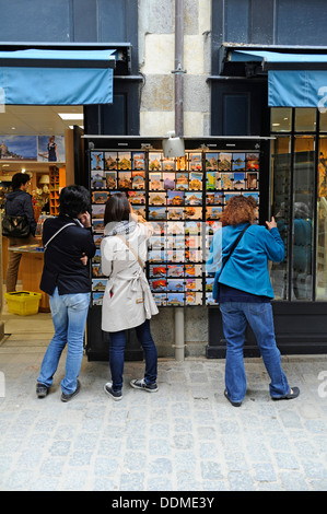 Turista femminile guardando le cartoline al di fuori di un negozio. Foto Stock