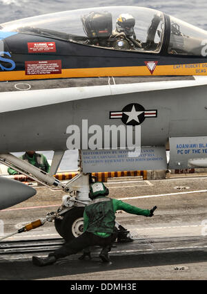 Navy US aviazione di Boatswain Mate Airman Derrick Brooks aiuta a preparare un F/A-18C Hornet Fighter Aircraft per lanciare fuori della portaerei USS Nimitz Settembre 3, 2013 operanti nel Mar Rosso. Nimitz Strike gruppo è dispiegato nella zona in preparazione di una possibile azione militare contro la Siria. Foto Stock