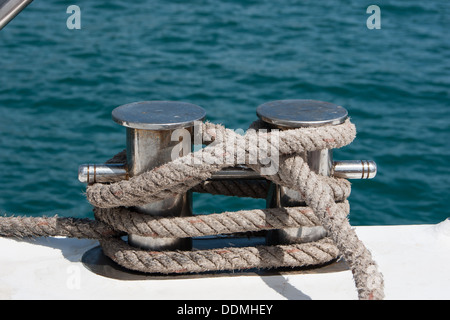 Nodo su un bollard di una imbarcazione. Mare blu in uno sfondo. Foto Stock