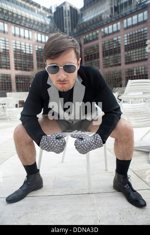 Cheeky giovane uomo nel quartiere alla moda di occhiali Foto Stock