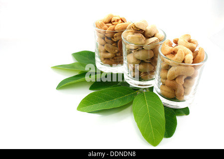 I pistacchi anacardi e arachidi in vetro su sfondo bianco. Foto Stock