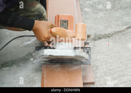 I lavoratori sono utilizzando una sega circolare per tagliare il legno. Foto Stock