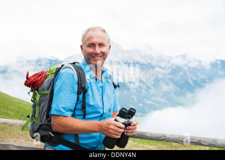 Escursionista con binoculare, Neunerkoepfle, Allgaeu Alpi, Valle di Tannheim, Tirolo, Austria, Europa Foto Stock