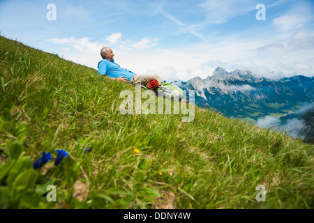 Escursionista sdraiati su un prato, Neunerkoepfle, Allgaeu Alpi, Valle di Tannheim, Tirolo, Austria, Europa Foto Stock