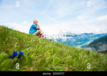 Escursionista seduto su un prato, Neunerkoepfle, Allgaeu Alpi, Valle di Tannheim, Tirolo, Austria, Europa Foto Stock