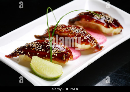 Il Sushi con anguilla su una piastra bianca. Foto Stock
