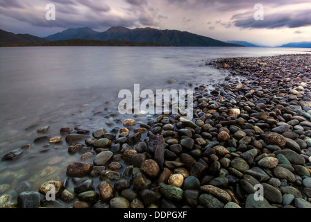 Rainbows oltre Fiordland montagne e Lago Te Anau all'alba. Isola del Sud, Nuova Zelanda Foto Stock