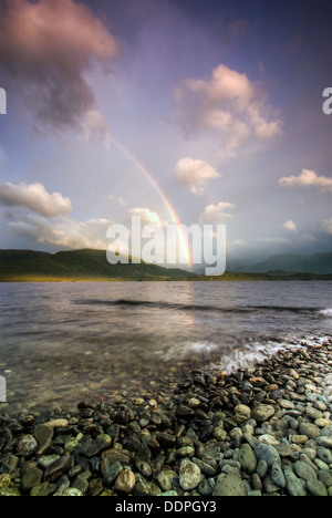 Rainbows oltre Fiordland montagne e Lago Te Anau all'alba. Isola del Sud, Nuova Zelanda Foto Stock