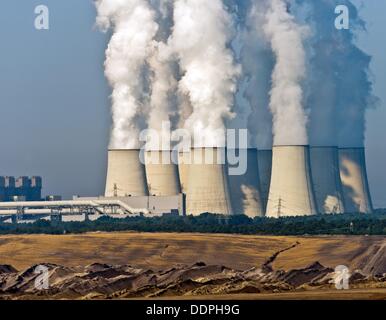 Vapore sorge la torre di raffreddamento della lignite fired Vattenfall power plant in Jaenschwalde, Germania, 29 agosto 2013. La striscia di lignite miniera è raffigurato in primo piano. Circa 60.000 tonnellate di lignite sono presi dalla striscia nelle miniere e Jaenschwald Cottbus-Nord ogni giorno. Foto: PATRICK PLEUL Foto Stock