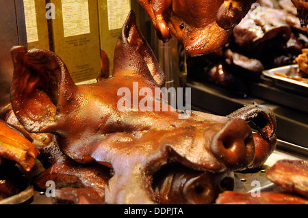 Intera testa di suini di stallo del mercato street venditore Foto Stock