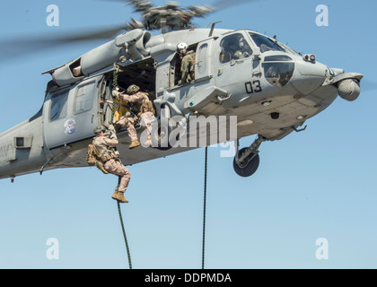 Marines assegnato al trentunesimo Marine Expeditionary Unit (MEU) fast-corda da un MH-60S Sea Hawk per il ponte di volo di distribuita Amphibious Assault nave USS Bonhomme Richard (LHD 6) durante un esercizio di formazione. Bonhomme Richard è la punta di diamante della Foto Stock