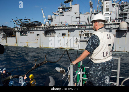 Lt. La Cmdr. James R. Bird, delegato del trasporto anfibio dock nave USS Denver (LPD 9) osserva come Denver conduce un rifornimento in corso (UNREP) con Amphibious Assault nave USS Bonhomme Richard (LHD 6). Denver è di pattuglia con il Bonhomme Foto Stock