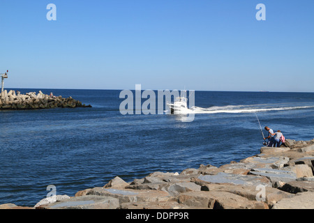 Una barca da pesca entrando nel Manasquan ingresso dall'Oceano Atlantico. Punto spiaggia piacevole, New Jersey, STATI UNITI D'AMERICA Foto Stock