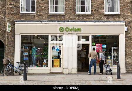 Le persone che cercano attraverso la finestra della carità di Oxfam shop in Cambridge, Inghilterra Foto Stock