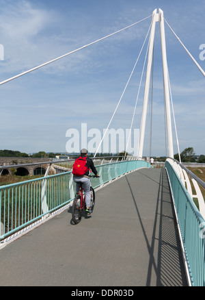 Ciclista attraversando la città nuova banchina ponte sul fiume Teign in Newton Abbot, England, Regno Unito Foto Stock