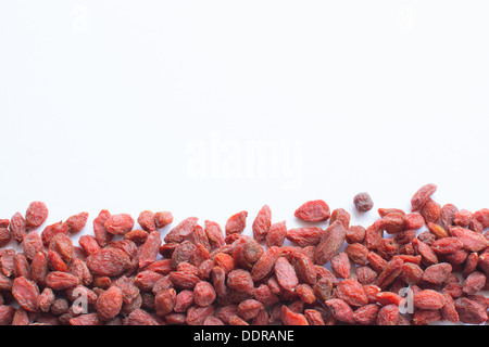 Bacche di Goji margine decor isolato su bianco Foto Stock