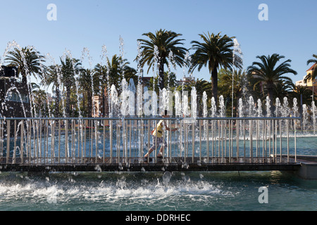 Bambino in esecuzione attraverso fontane al Palm Promenade Salou Foto Stock