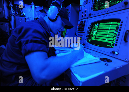 Tecnico di sonar (Superficie) marinaio Daniel Kline esegue acustici passivi in analisi il sonar sala di controllo a bordo del guidato-m Foto Stock