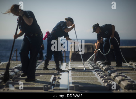 Mare Mediterraneo (sett. 2, 2013) da bombardieri Mate 2a classe Emily Haas, sinistra, specialista di operazioni di seconda classe Kendal Tamigi e da bombardieri Mate Miranda marrone a eseguire un lavaggio in acqua dolce verso il basso sul bordo guidato-missile destroyer USS Barry (DDG 52). Barry è su un Foto Stock