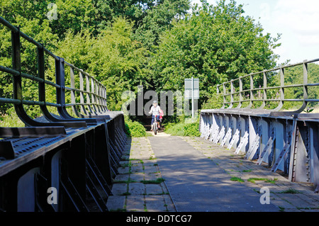 I ciclisti attraversando un vecchio ponte ferroviario sul Marriott il modo della distanza lungo il sentiero a Lenwade, Norfolk, Inghilterra, Regno Unito. Foto Stock